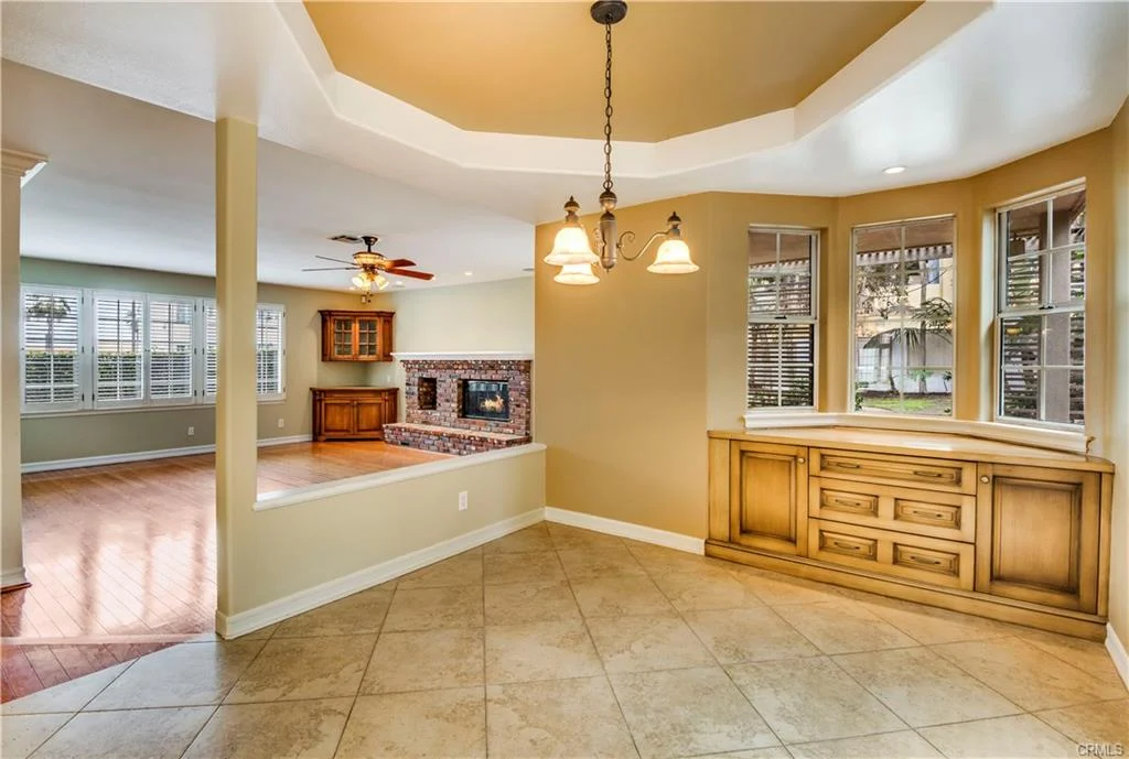 living area with tile floor, cabinet, windows with blinds, and fireplace