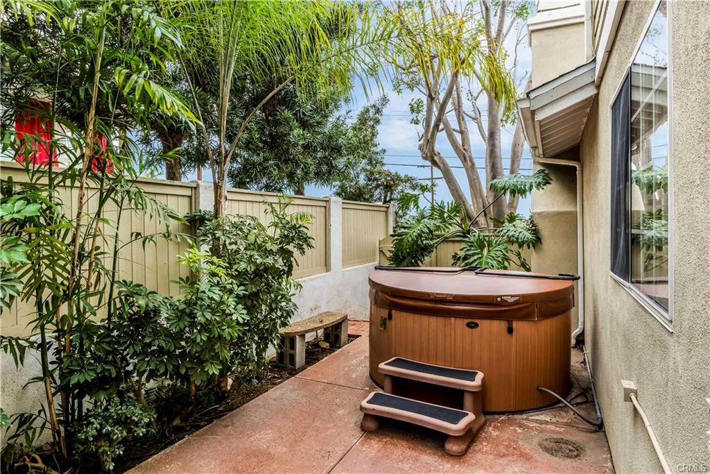 California real estate with a red patio, hot tub, and palm trees.