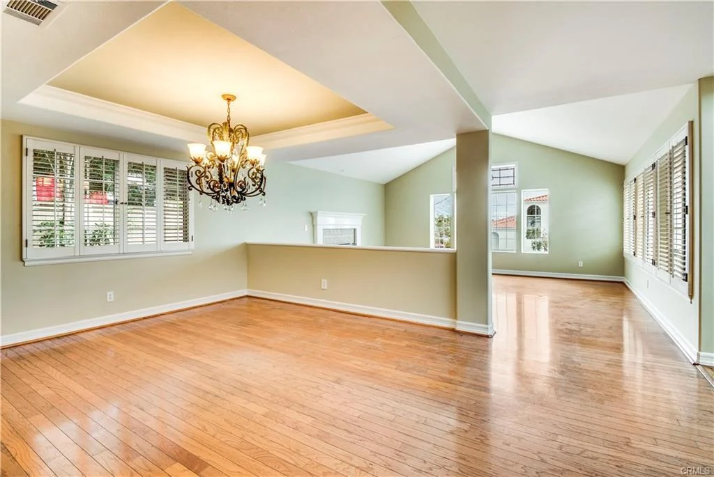 Room with wood floors, a fireplace, and big windows.