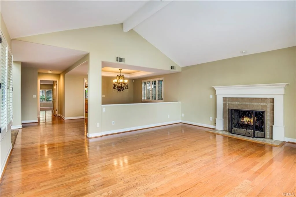room with wood floors, a fireplace, and big windows.