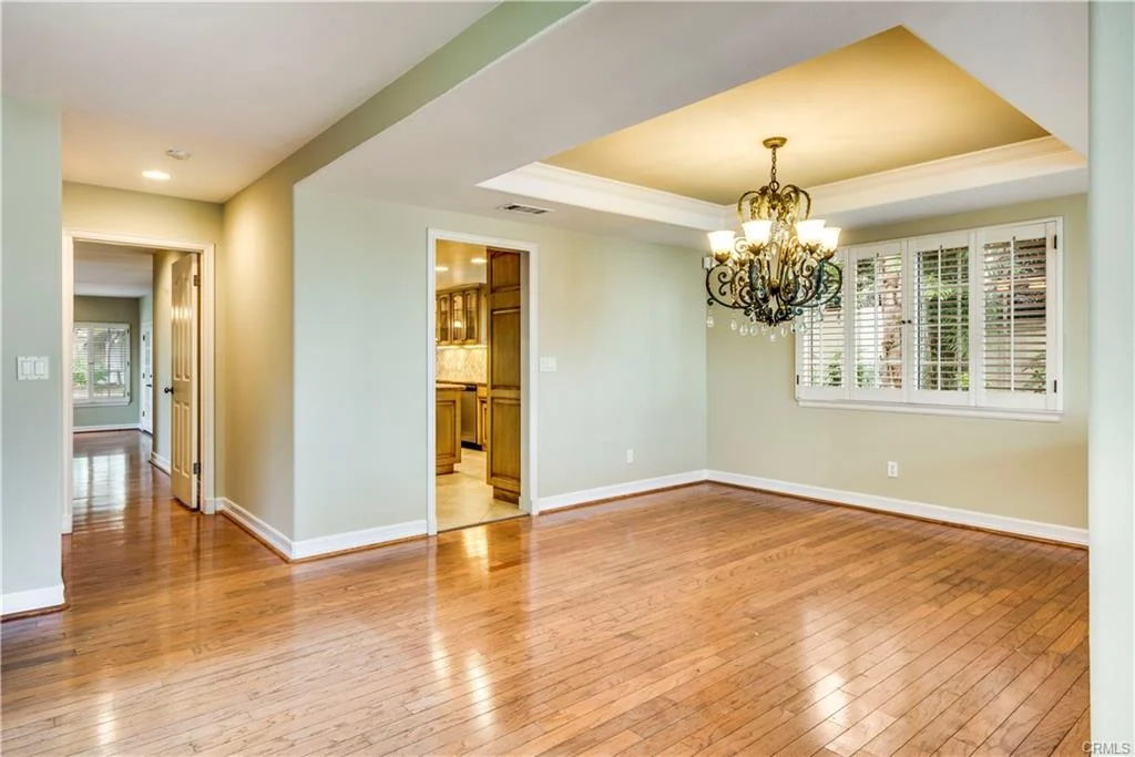 room with green walls, wood floors, and a light.