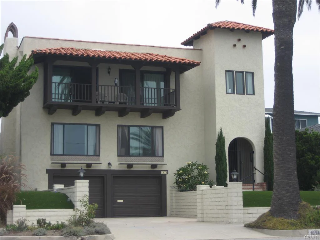 House in California real estate with tile roof, balcony, driveway, garage, and palm trees