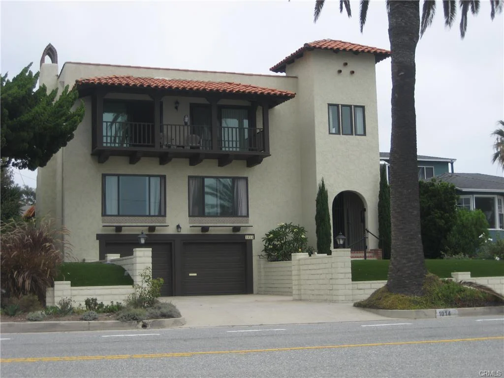 Luxury house in California real estate with balcony, palm trees, and yard
