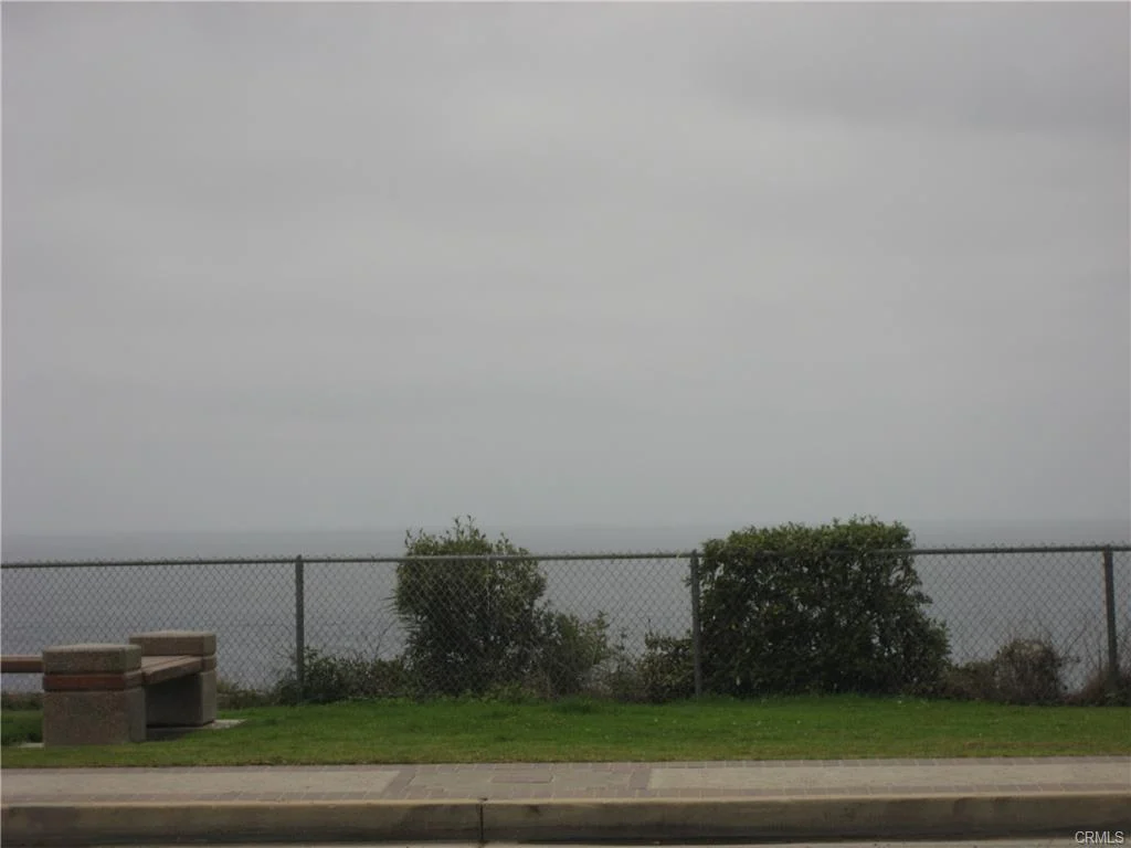 View of Ocean with bench, fence, and plants