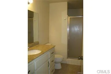 Bathroom with shower, toilet, and sink vanity.