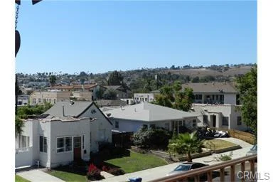 Neighborhood with California real estate houses, trees, and hills.
