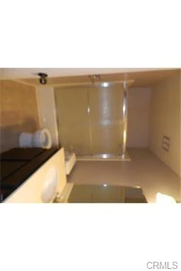 Bathroom with shower, toilet, sink, and light walls.