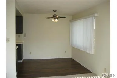 Kitchen with dark cabinets, white fridge, gas stove, and sink under window.