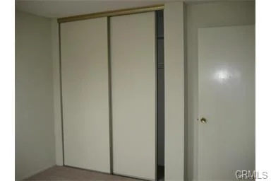 Room with sliding closet door and white door.