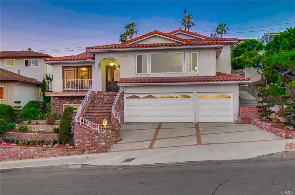 Luxury house in California real estate with red tile roof, stairs, yard, driveway, and garage