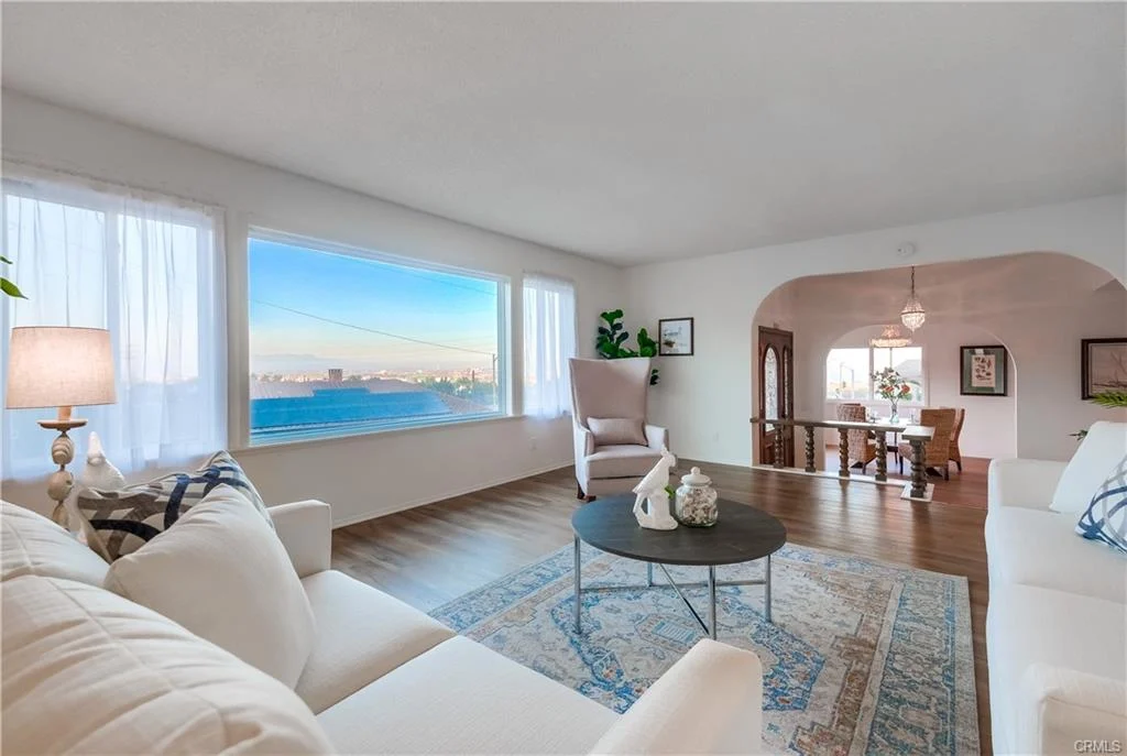 Living room with white sofa, coffee table, and window view outside