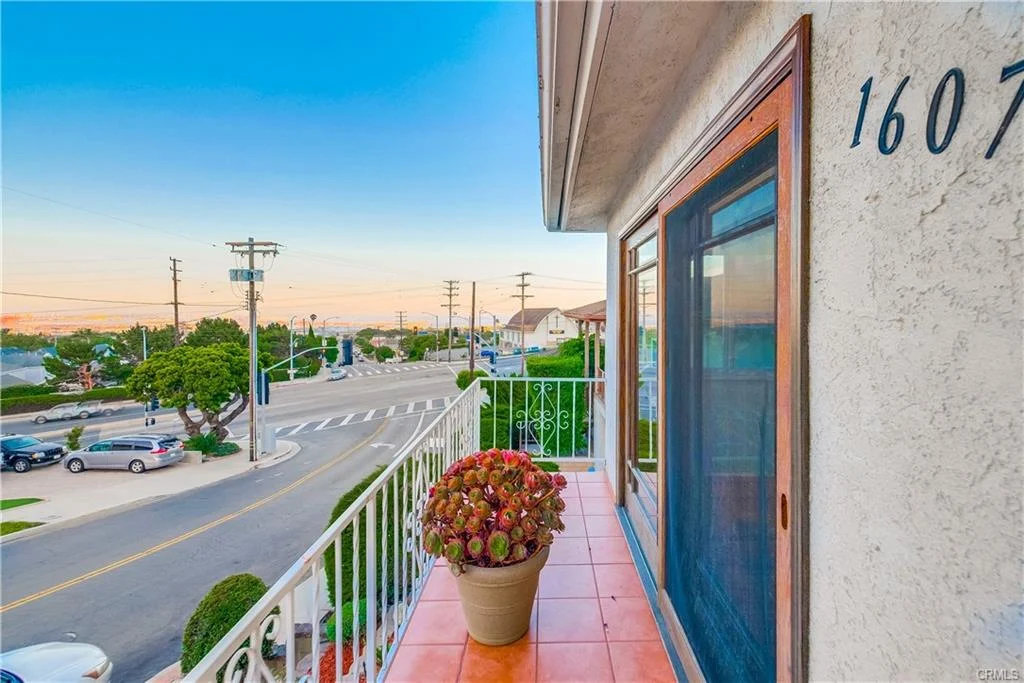 Balcony view with plant, street, houses, and power lines in California real estate