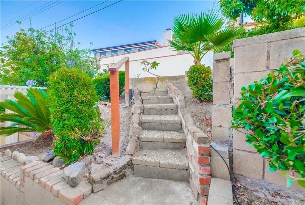 Stairs with greenery, brick wall, and concrete wall