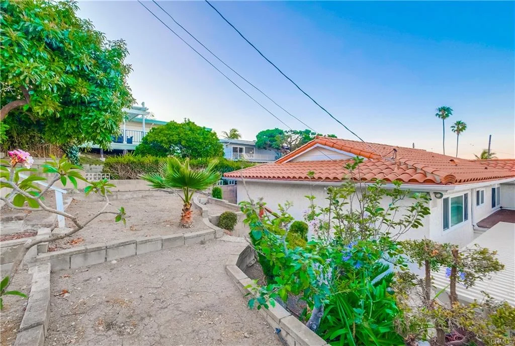 House in California real estate with tile roof, plants, trees, and power lines