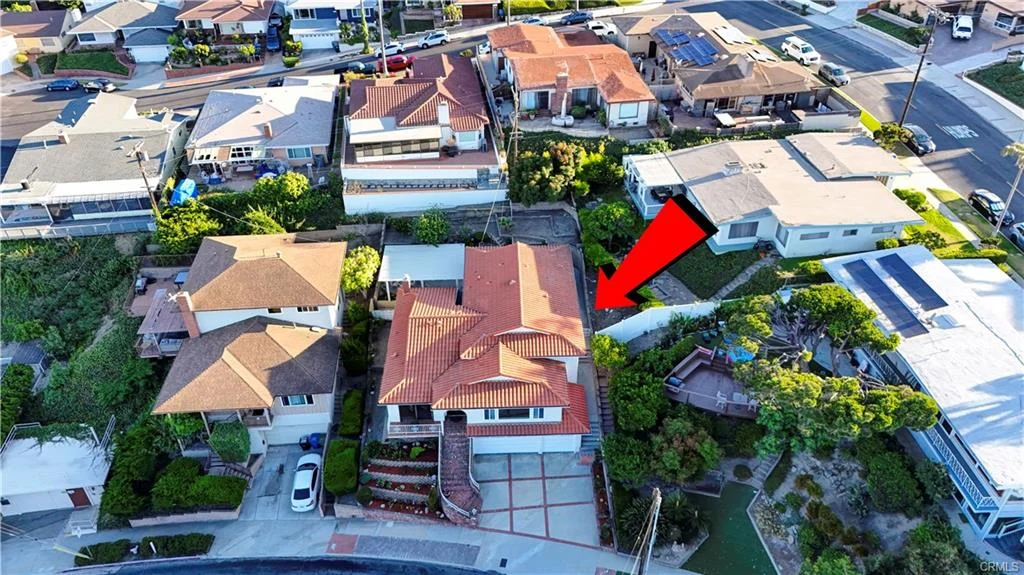 Aerial view of neighborhood with houses and arrow pointing to one house in California real estate