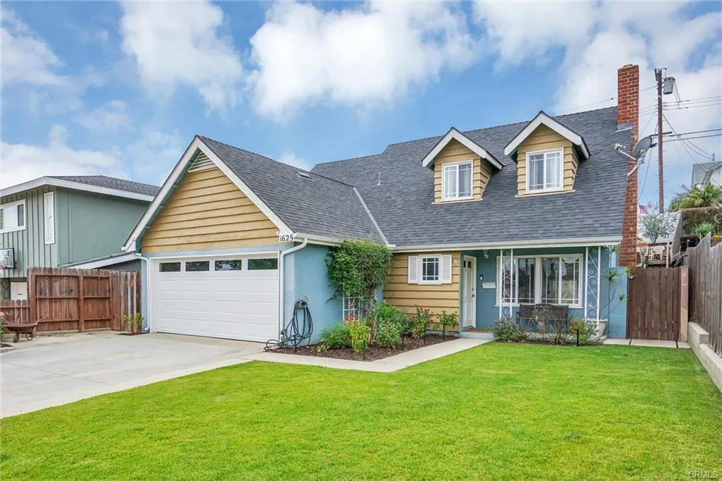 California real estate house with garage, driveway, green grass, and landscaping.