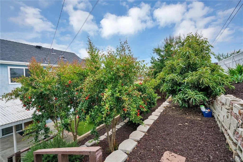 Garden with trees, plants, and stone pathway.
