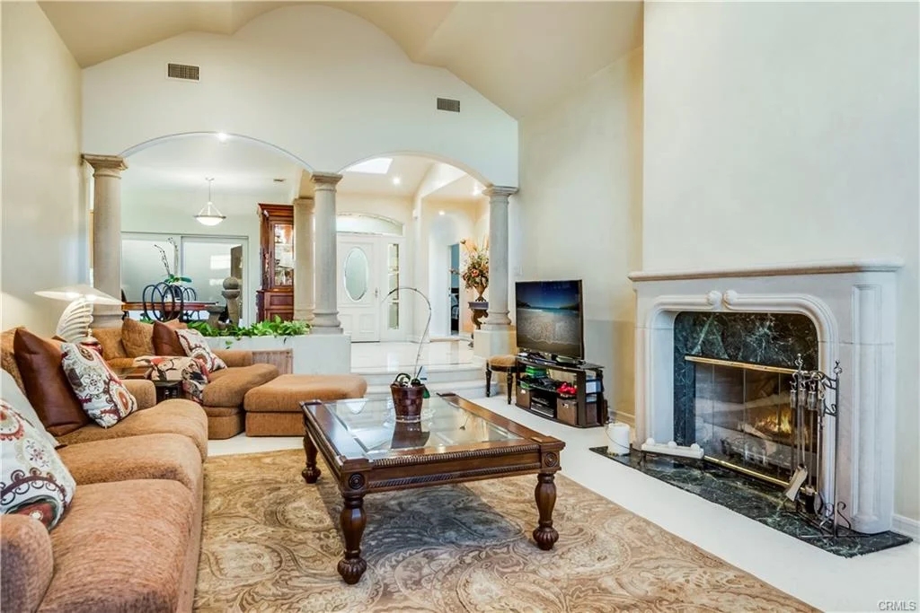 Living room with large sofa, coffee table, and fireplace.