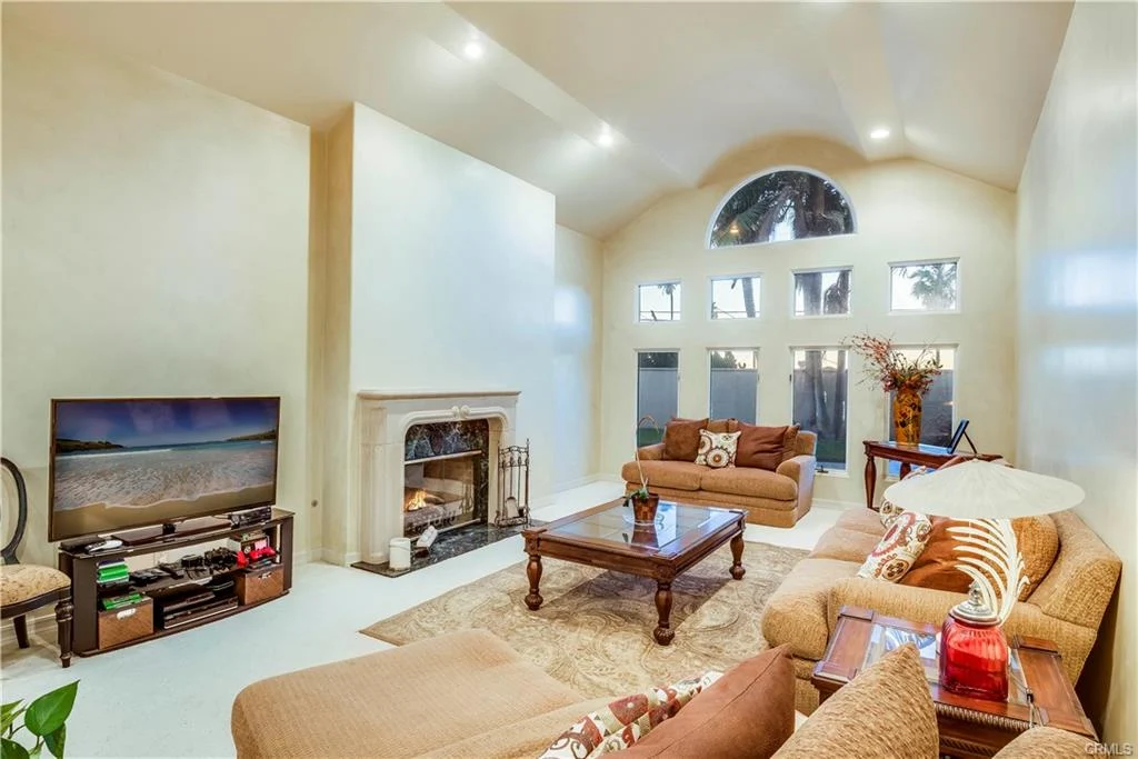 Living room with fireplace, windows, and seating.