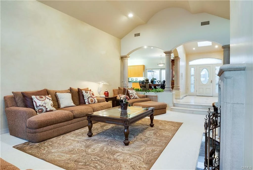 Living room with large sofa, coffee table, and area rug.