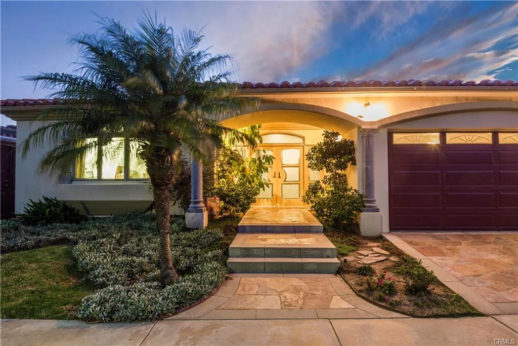 Home exterior with entrance, stone pathway, and plants, California real estate.
