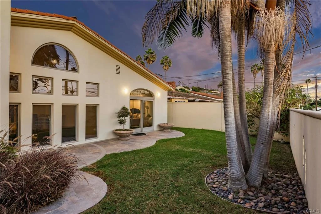 A Luxury House with a lawn, tall palm trees, and potted plants, California real estate