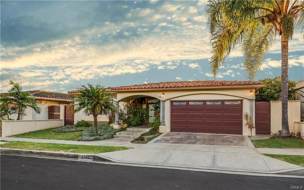 Single-story house with tiled roof, palm trees, and front yard, California real estate.