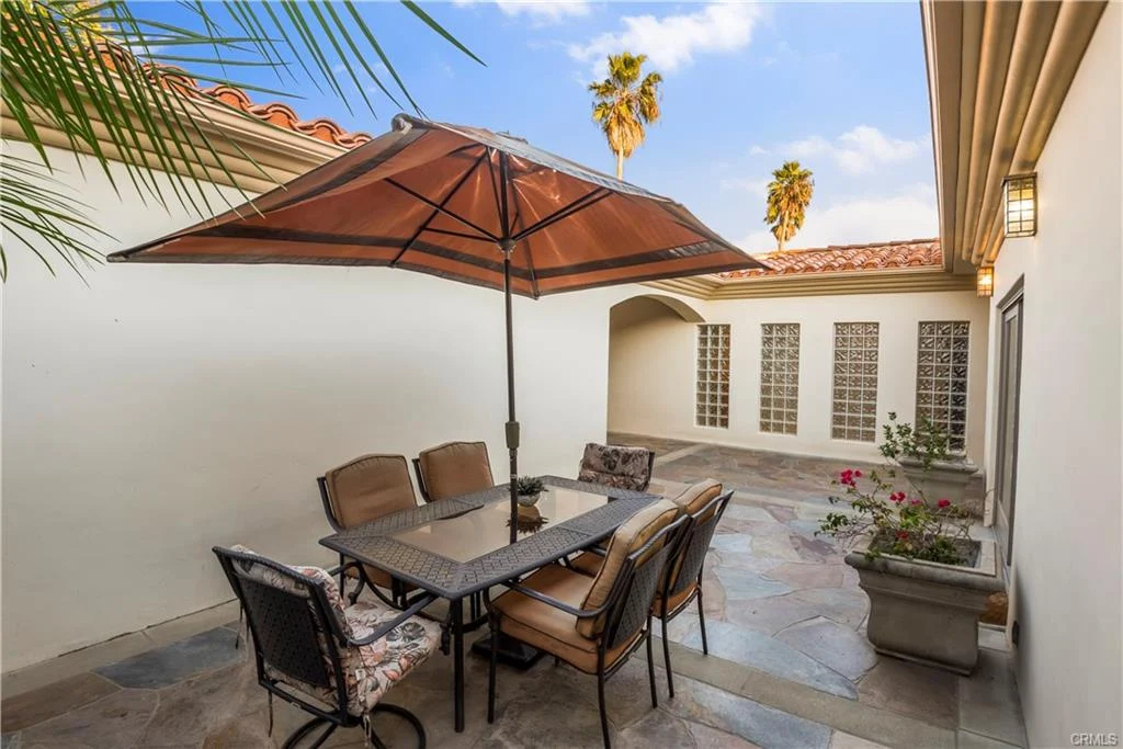 Entryway with front door, console table, mirror, and flowers.