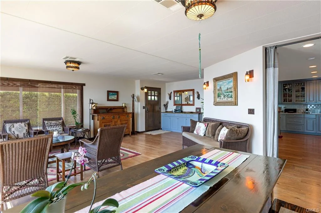 Living room with seating, table, wall art, and windows