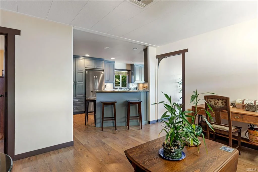 Kitchen with blue cabinets, stainless steel appliances, and bar seating
