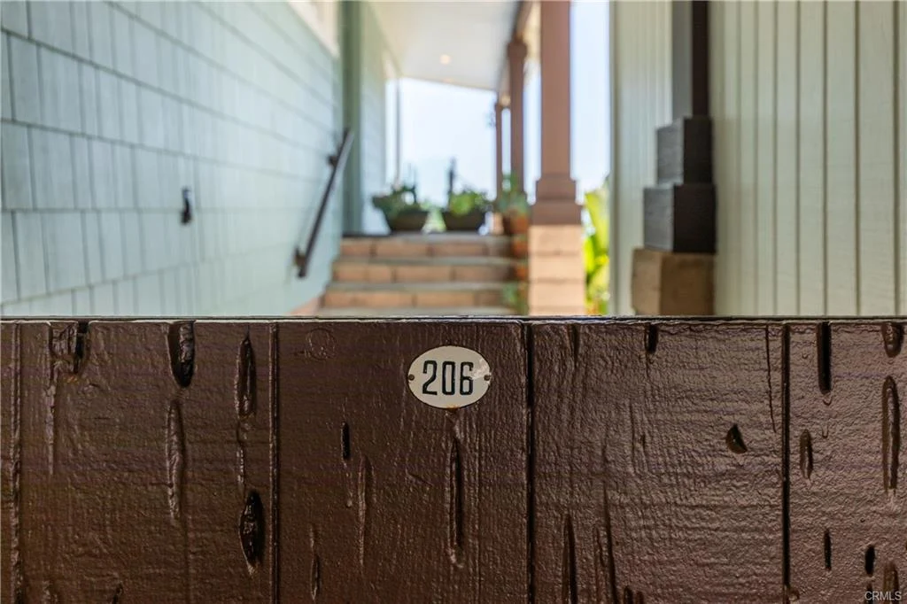 Wood door with number 206 and blurred porch background