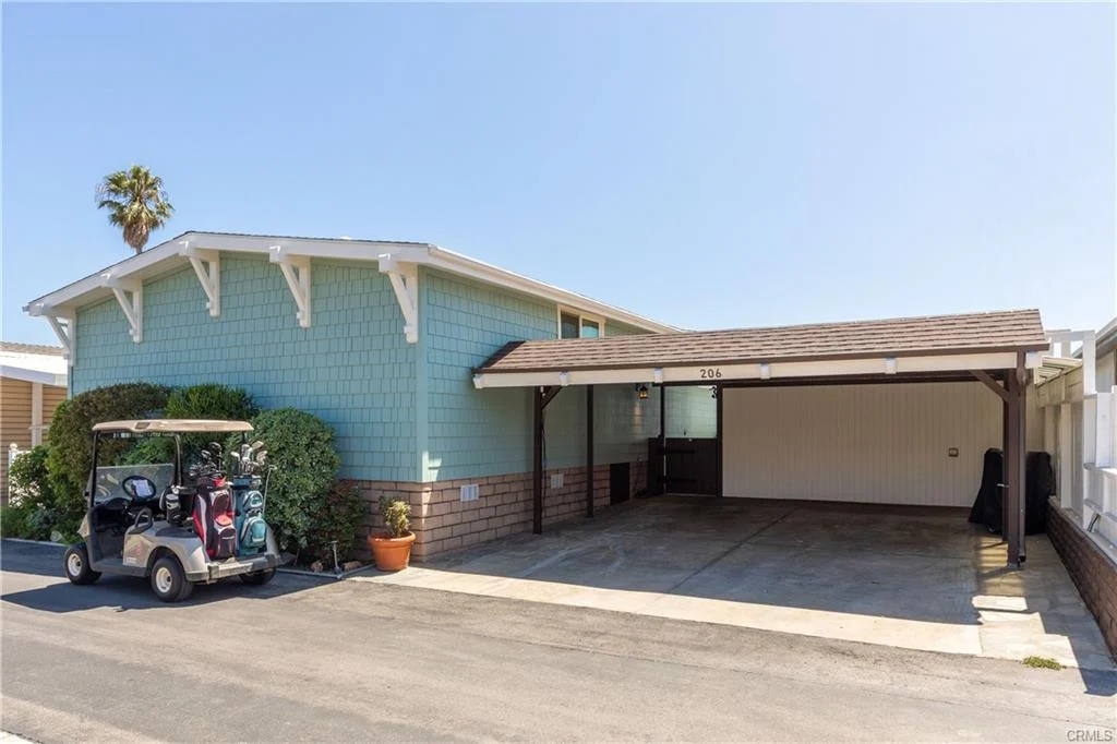House in California real estate with carport, palm tree, and golf cart nearby