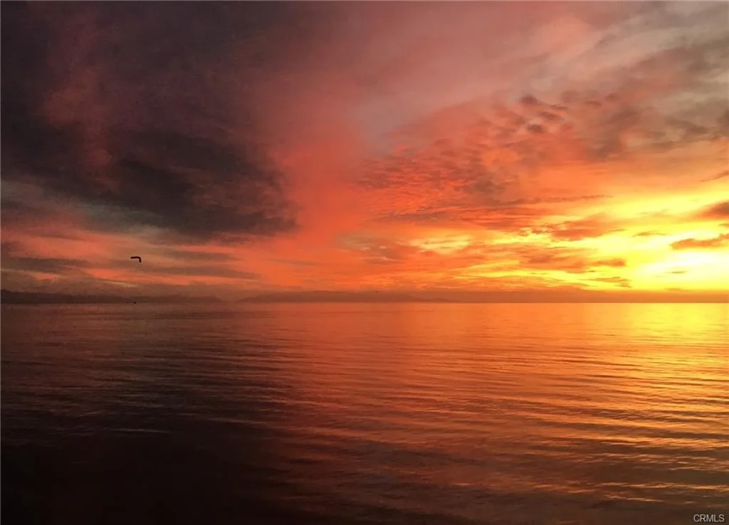 Sun over calm ocean with bright colors reflecting on the ocean