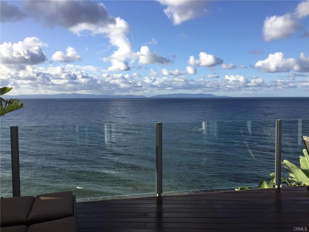 Ocean view from wooden deck with clouds and islands