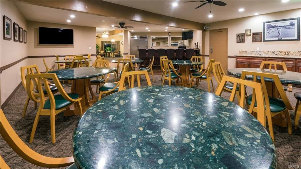 Dining area with marble tables, yellow chairs, pictures, and bar counter