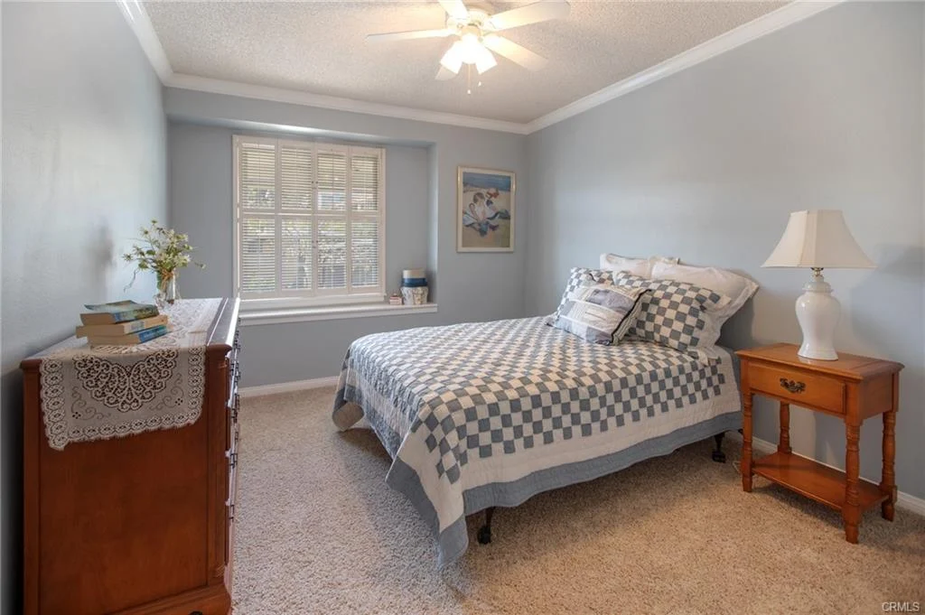 Bedroom with bed, nightstand, dresser, and window.