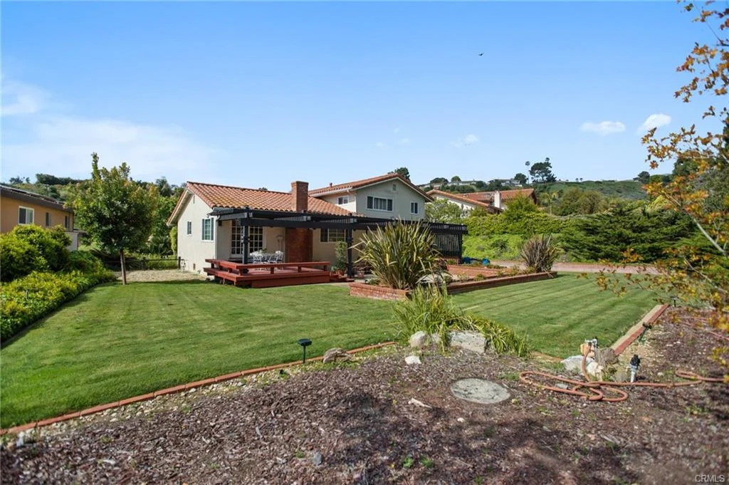 House with patio, garden, red-tiled roof, and lawn, California real estate.