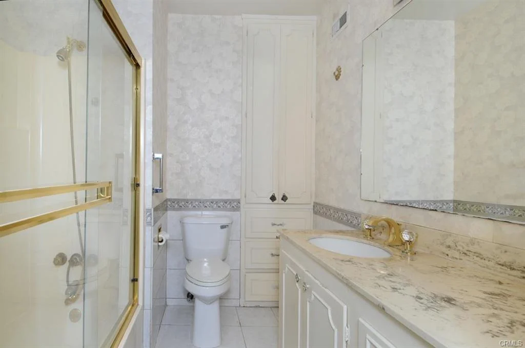 Bathroom with shower, toilet, sink, counter, and mirror