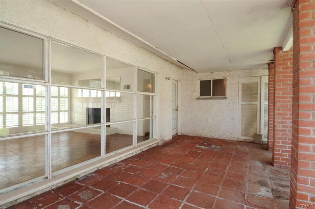 Empty room with tile floor, windows, and door