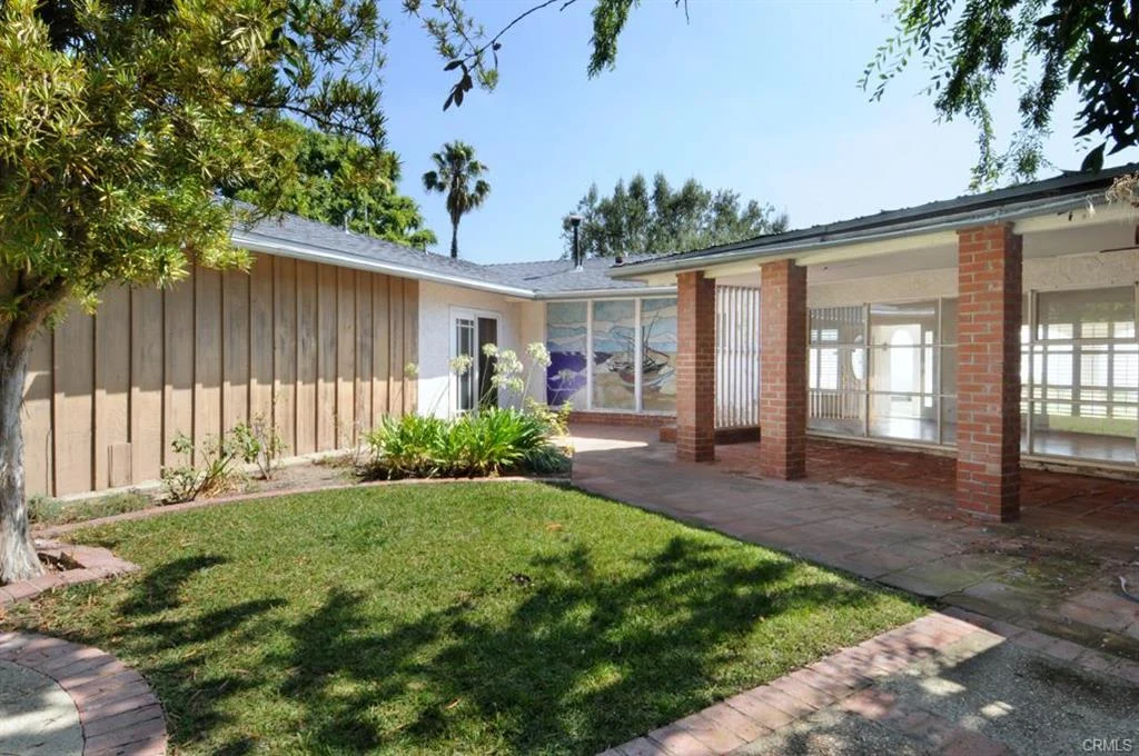 House in California real estate with yard, brick pillars, windows, and plants