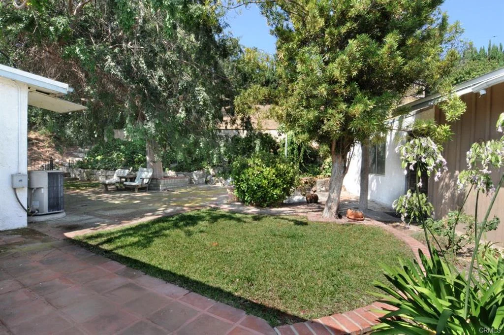 Backyard with grass, trees, and patio furniture