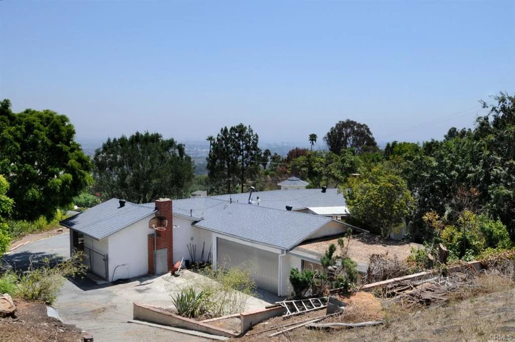 House in California real estate with gray roof, driveway, trees, and plants
