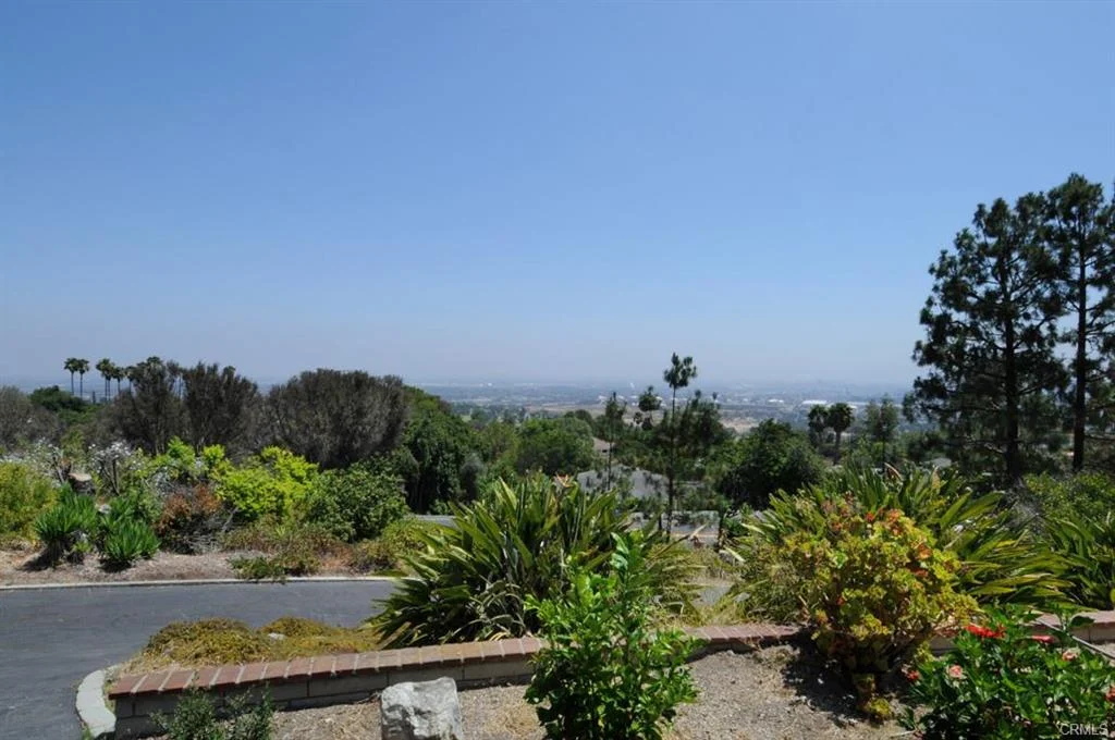 Hillside view with garden, plants, trees, and valley