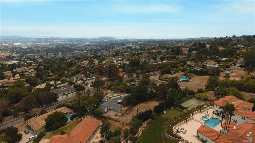 Aerial view of neighborhood with houses, pools, and greenery in California real estate
