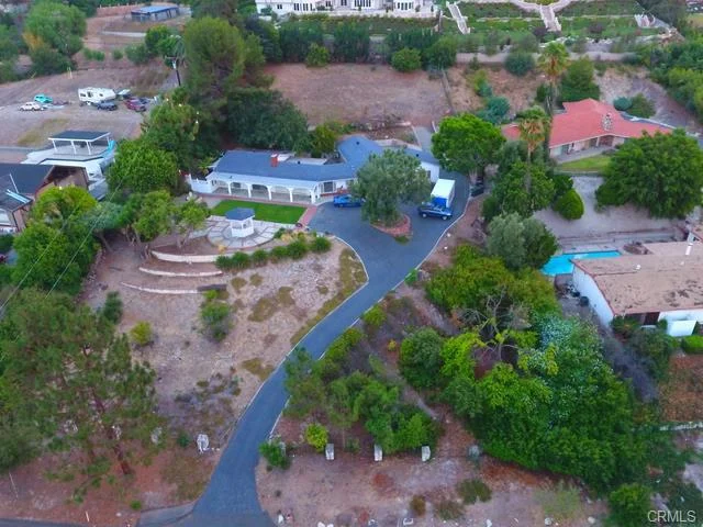 Aerial view of neighborhood with houses, yards, driveways, and trees in California real estate