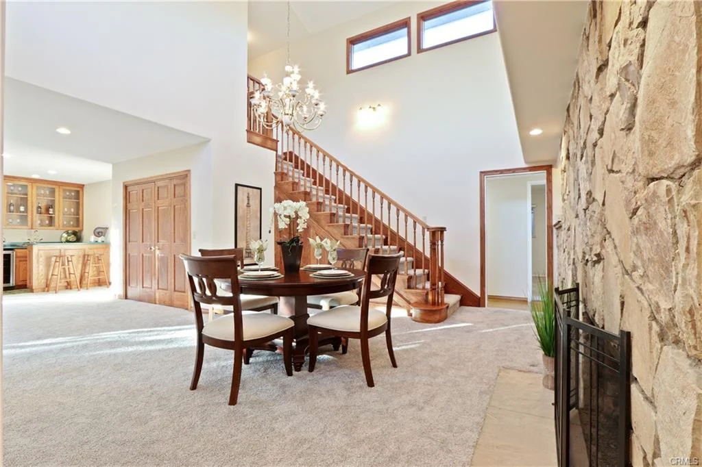 Interior space with dining table, chairs, fireplace, and staircase.