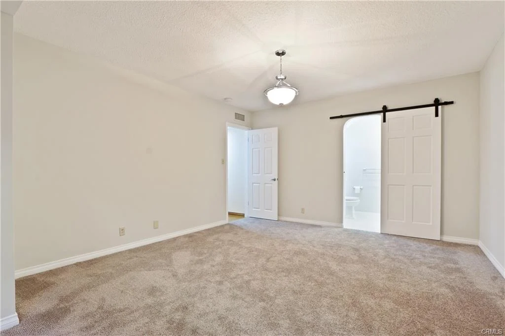 Room with light walls, carpet, and sliding door.