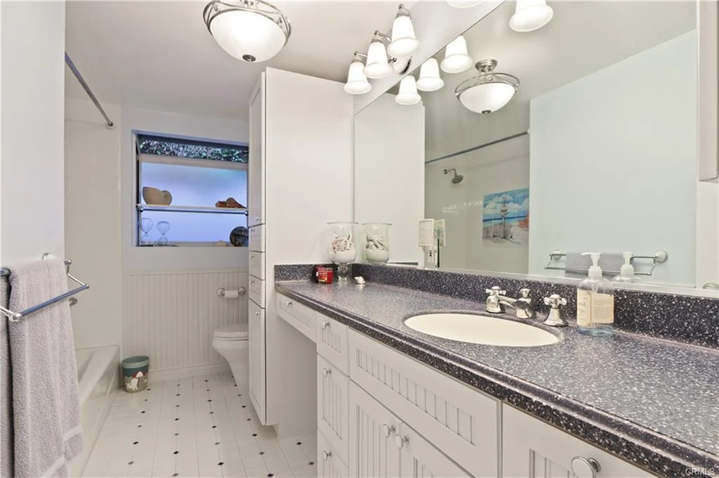 Bathroom with white vanity, double sinks, and tiled floor