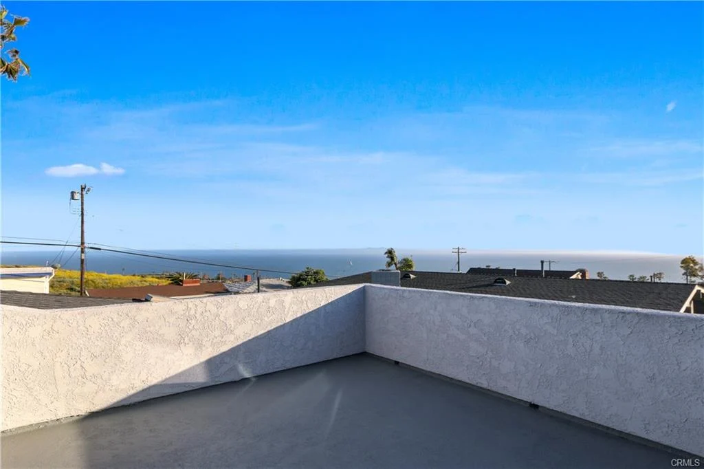 Rooftop terrace with ocean view and coastal scenery.
