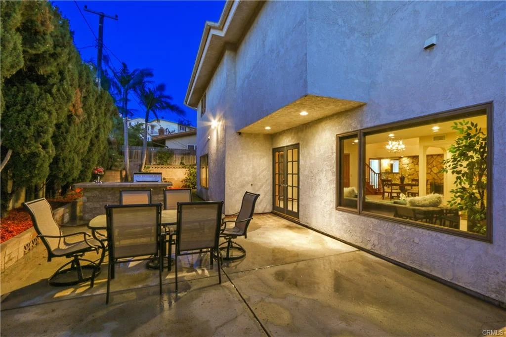 Patio with table, chairs, and plants.